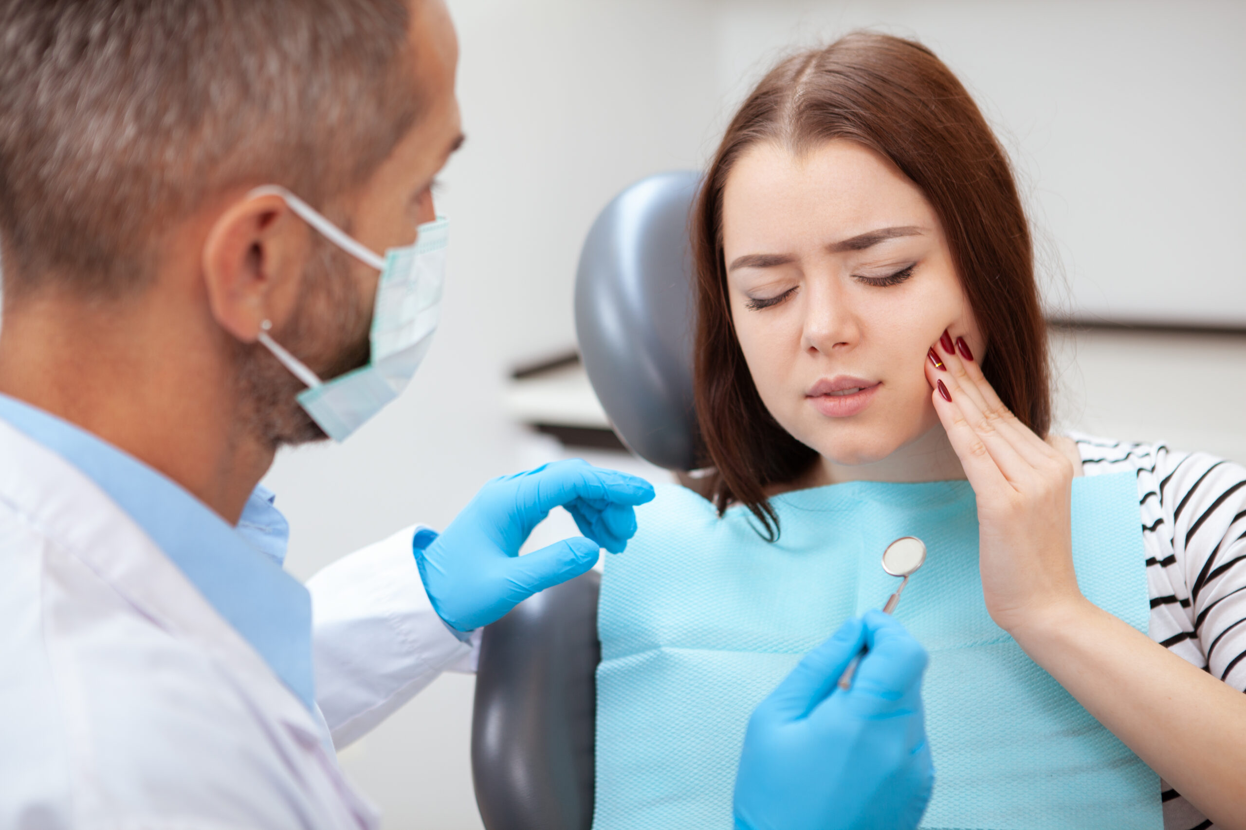 Young woman with tooth pain visiting the dentist