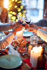 People eating a Christmas dinner together with a glass of wine