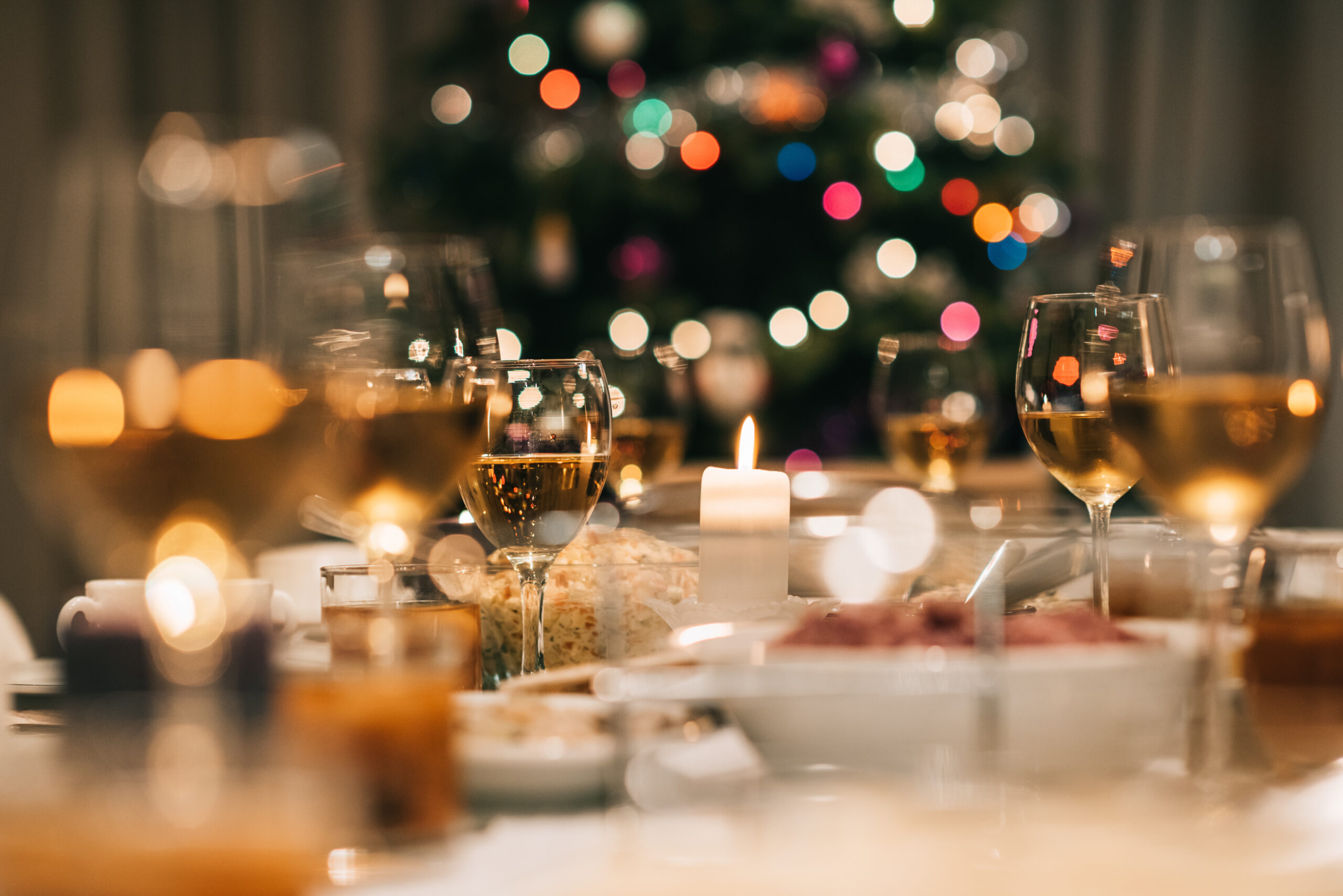 Christmas dinner with glasses of wine and lights lighting up the table